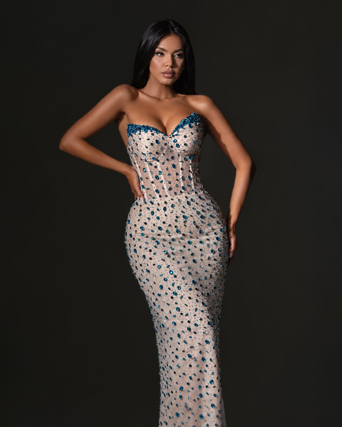 Nude strapless corset column gown with teal blue crystal embellishment, front view