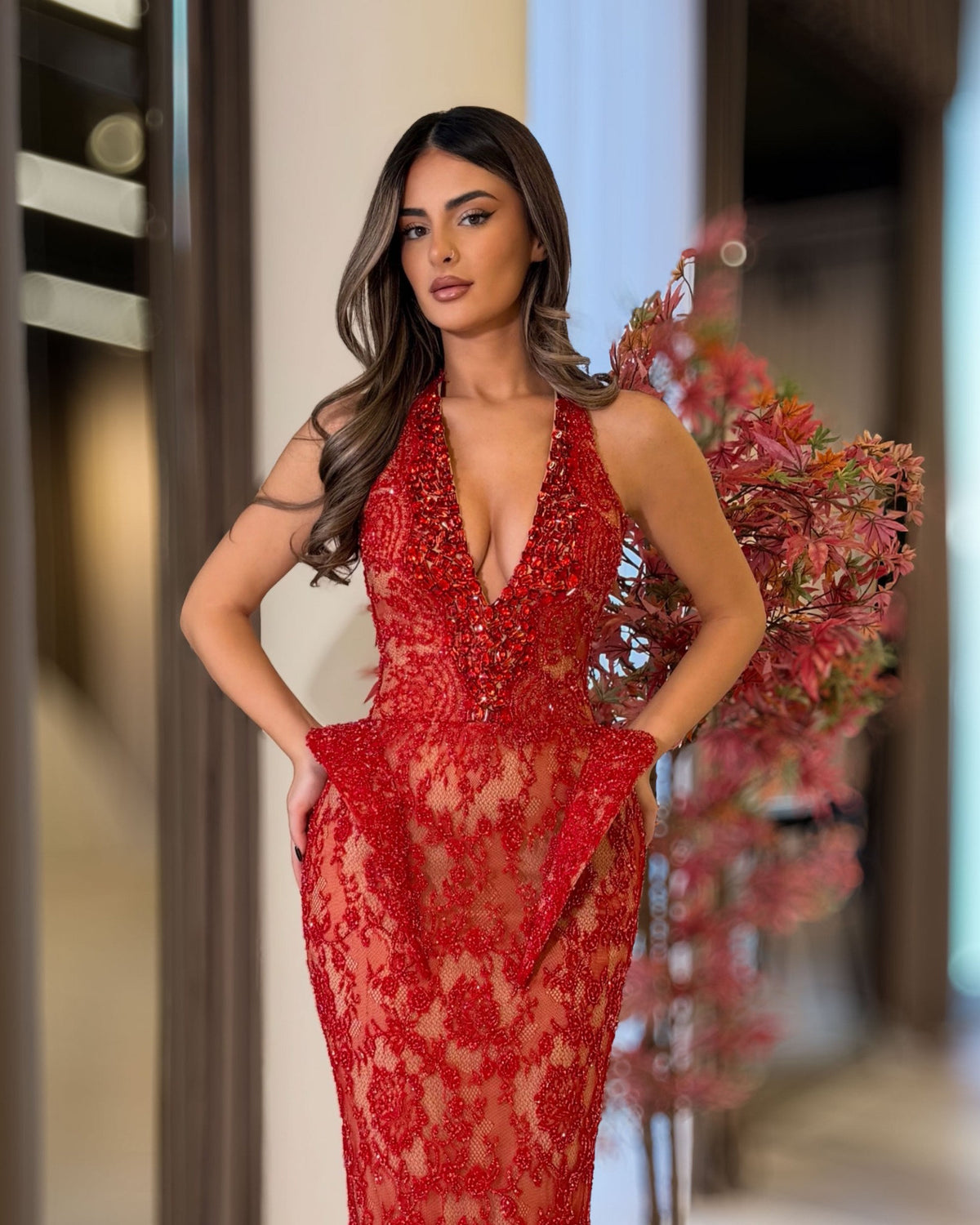 Red lace halter corset gown with crystal plunge neckline and sculpted hips, angled view